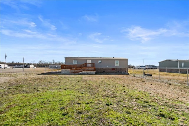 rear view of property featuring a yard and a wooden deck