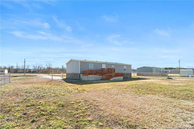 rear view of property featuring a deck and a lawn