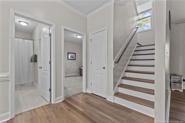 staircase featuring hardwood / wood-style floors and crown molding