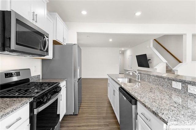 kitchen featuring sink, white cabinets, light stone counters, dark hardwood / wood-style floors, and appliances with stainless steel finishes