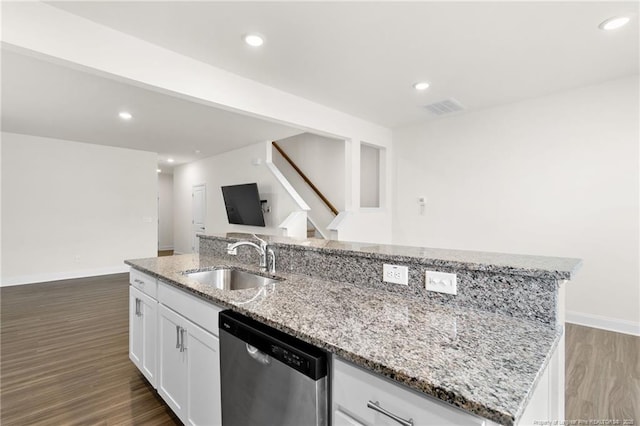 kitchen with light stone countertops, stainless steel dishwasher, a center island with sink, white cabinets, and sink