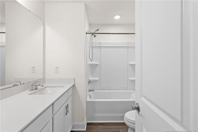 full bathroom featuring toilet, vanity, hardwood / wood-style flooring, and washtub / shower combination