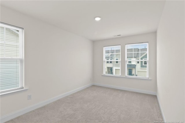 spare room featuring light colored carpet