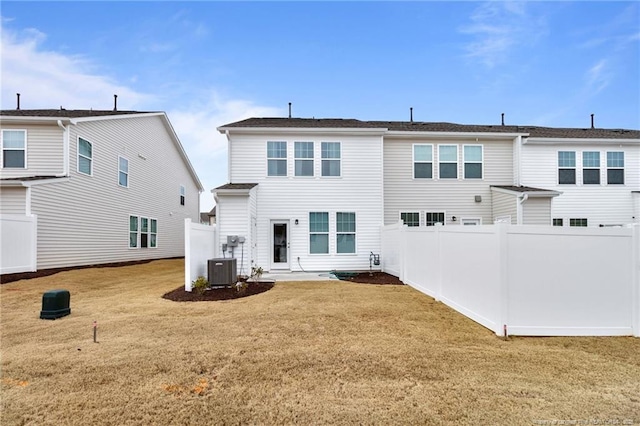 rear view of house with central AC, a patio area, and a lawn