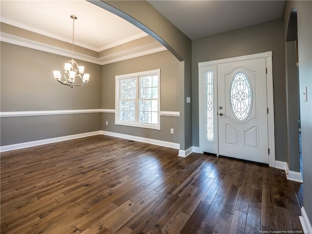 foyer entrance featuring a chandelier, ornamental molding, and dark hardwood / wood-style floors