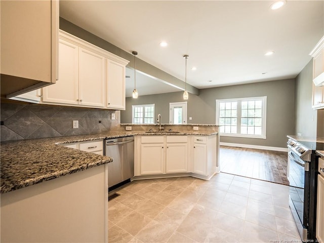 kitchen featuring stainless steel appliances, white cabinets, and decorative light fixtures