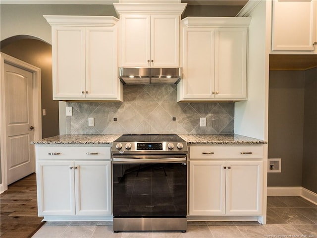 kitchen with light stone counters, stainless steel range with electric cooktop, tasteful backsplash, and white cabinetry