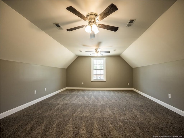 additional living space featuring lofted ceiling, dark colored carpet, and ceiling fan