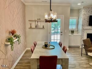 dining room with a fireplace, hardwood / wood-style floors, and crown molding