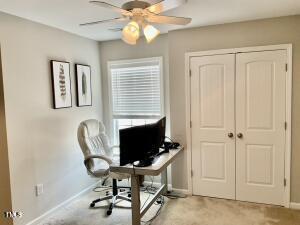 carpeted office with ceiling fan