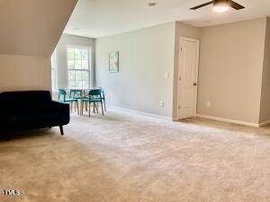 living area with light colored carpet and ceiling fan