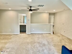 unfurnished room with ceiling fan and carpet