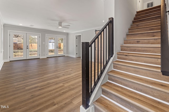 stairs with french doors, ceiling fan, hardwood / wood-style flooring, and ornamental molding