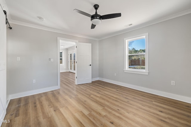 empty room with light wood-type flooring, ceiling fan, and crown molding