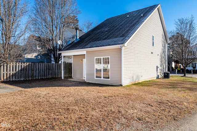 rear view of house featuring a yard and central AC unit