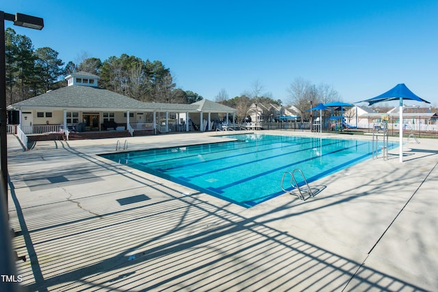 view of pool with a patio and a playground