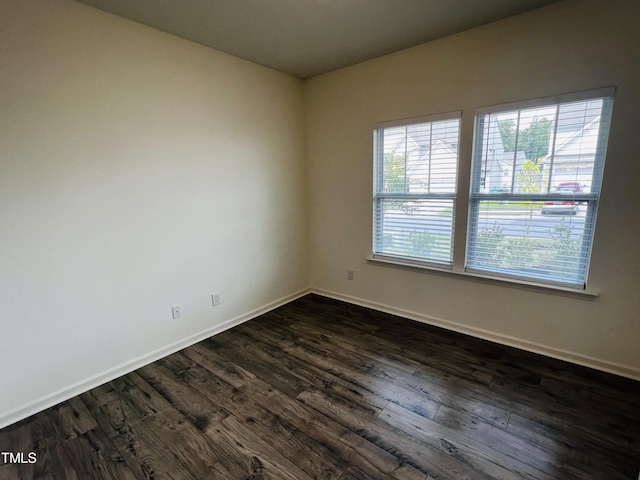 unfurnished room with a healthy amount of sunlight and dark hardwood / wood-style flooring