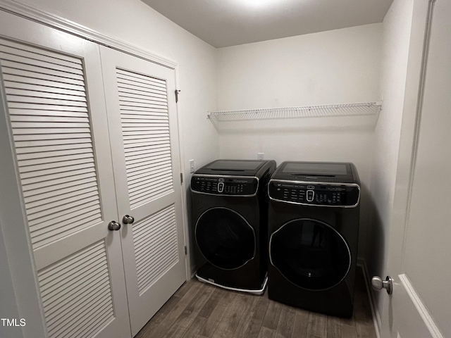 washroom with dark wood-type flooring and washer and clothes dryer