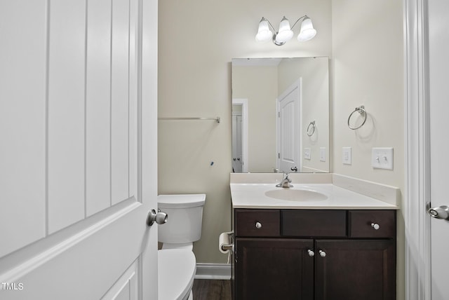 bathroom featuring baseboards, toilet, and vanity