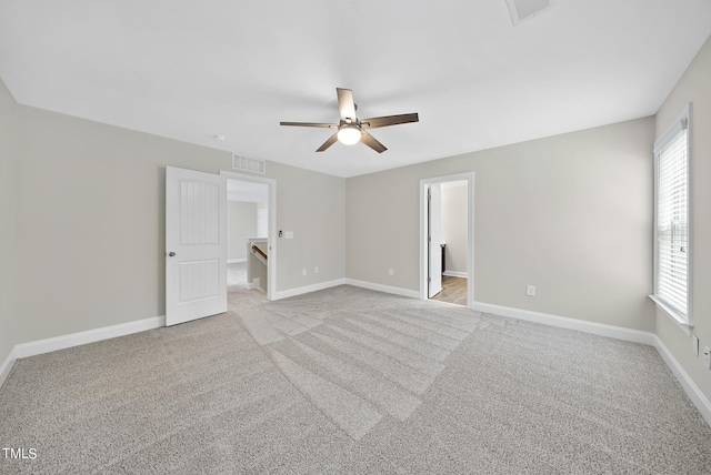 unfurnished bedroom with a ceiling fan, light colored carpet, visible vents, and baseboards