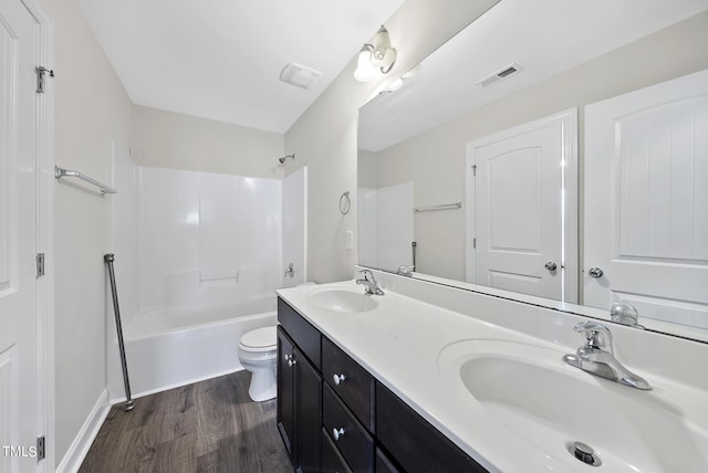 bathroom featuring toilet, wood finished floors, visible vents, and a sink