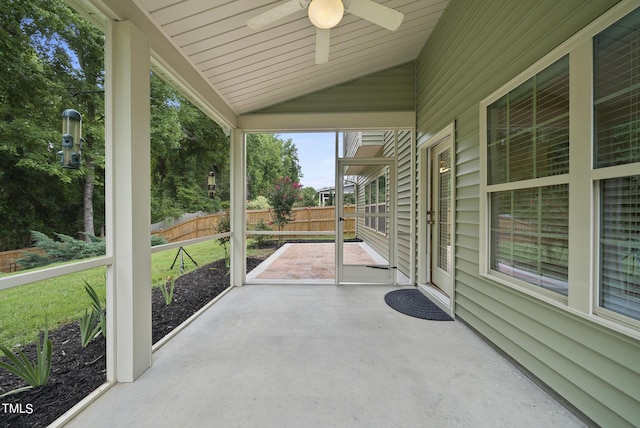 unfurnished sunroom with lofted ceiling and a ceiling fan