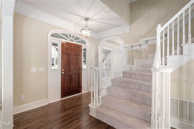 entrance foyer with hardwood / wood-style flooring, crown molding, and a notable chandelier