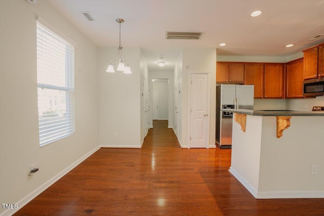 kitchen with a chandelier, a breakfast bar area, appliances with stainless steel finishes, plenty of natural light, and decorative light fixtures