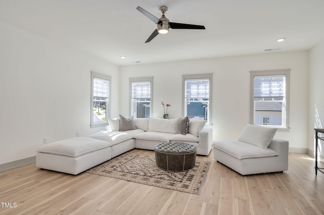 living room featuring ceiling fan and light hardwood / wood-style flooring