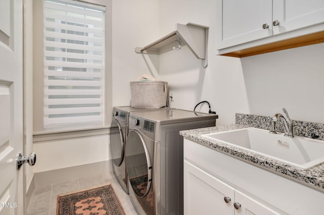 laundry room featuring sink, tile patterned flooring, washing machine and clothes dryer, and cabinets