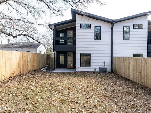 back of house with a balcony, central air condition unit, and a patio area