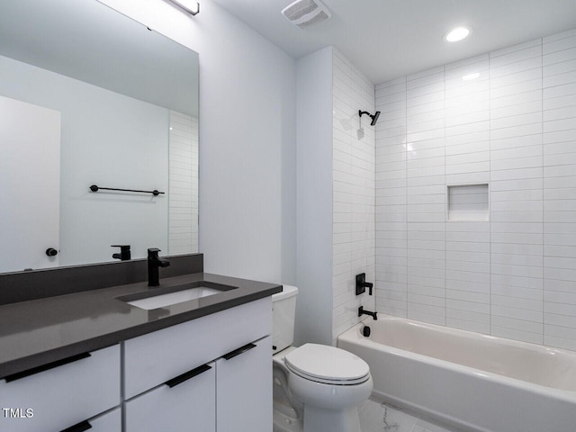 full bathroom with toilet, vanity, and tiled shower / bath