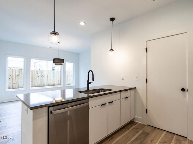 kitchen with sink, white cabinetry, kitchen peninsula, stainless steel dishwasher, and hanging light fixtures