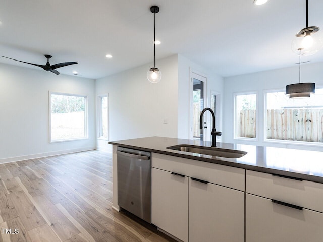 kitchen with sink, white cabinetry, dishwasher, a healthy amount of sunlight, and hanging light fixtures