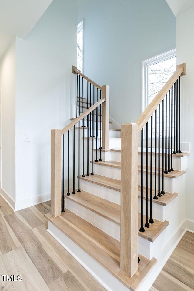 stairway with lofted ceiling and hardwood / wood-style flooring