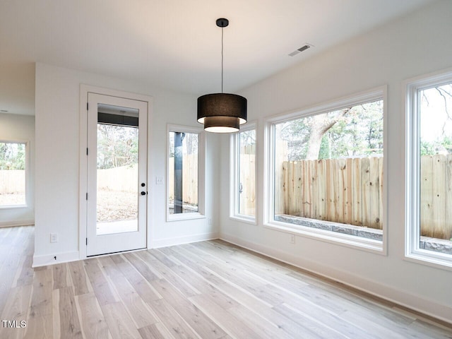 unfurnished dining area with light wood-type flooring