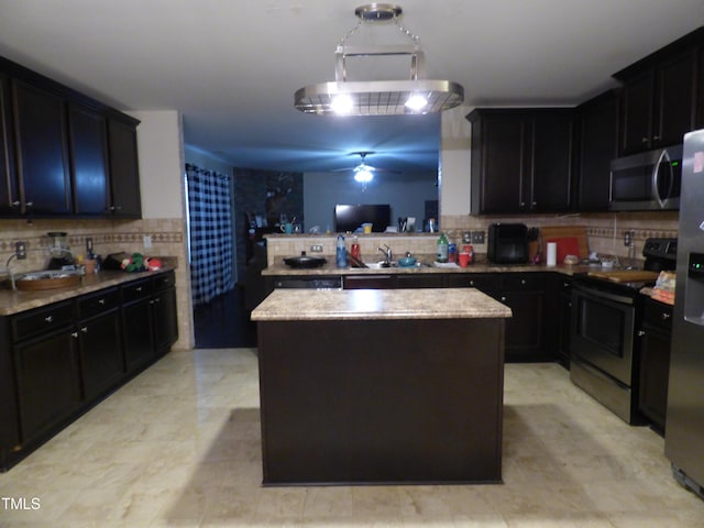 kitchen with decorative backsplash, a center island, a peninsula, stainless steel appliances, and a sink