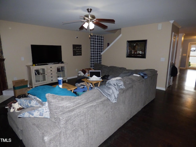 living room with a ceiling fan, baseboards, and wood finished floors