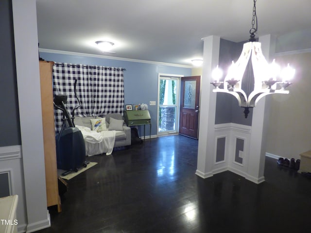 interior space featuring baseboards, ornamental molding, wood finished floors, and a notable chandelier