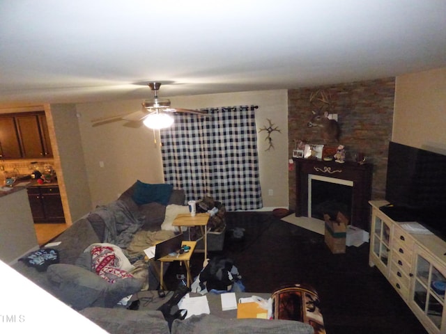 living room featuring a fireplace and ceiling fan