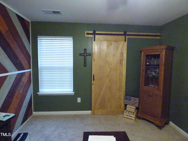 interior space with a barn door, visible vents, and baseboards