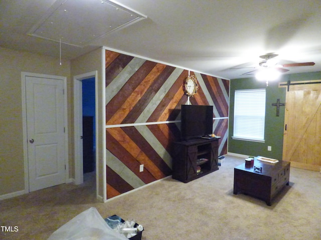 additional living space with attic access, carpet flooring, wooden walls, and a barn door