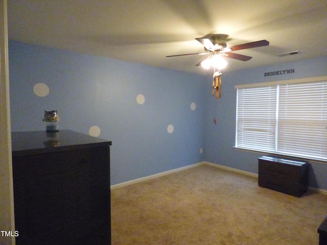 unfurnished bedroom with baseboards, visible vents, ceiling fan, and light colored carpet