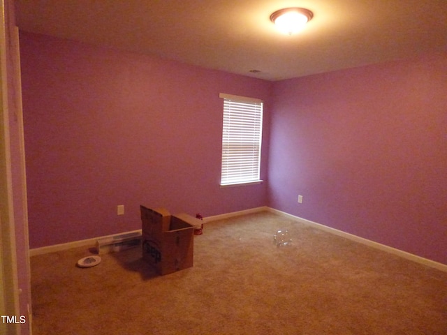 carpeted empty room featuring baseboards