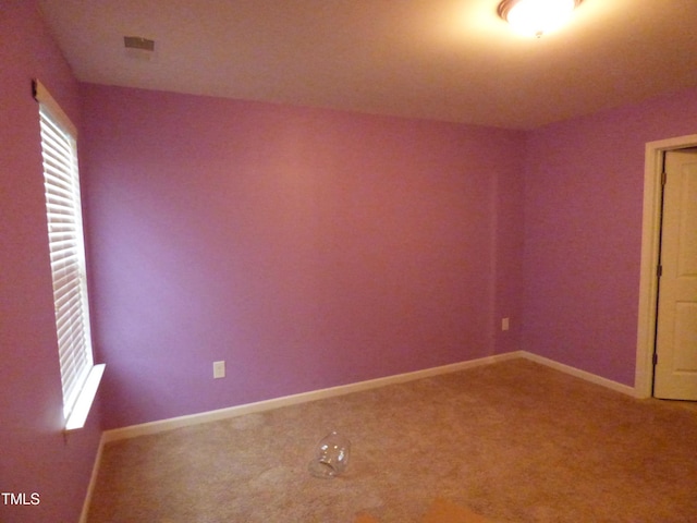 unfurnished room featuring carpet floors and baseboards