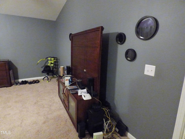 carpeted bedroom with lofted ceiling and baseboards