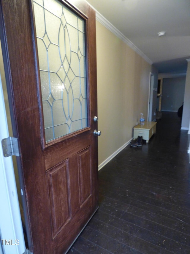 entryway with ornamental molding, dark wood-type flooring, and baseboards