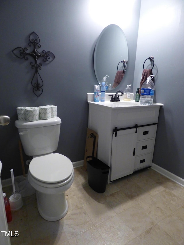 half bathroom with toilet, vanity, and baseboards