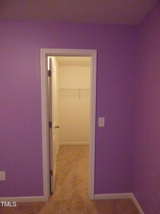 corridor featuring light carpet and baseboards