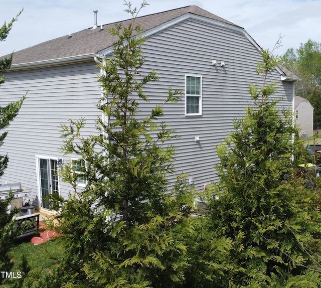view of side of home with a shingled roof